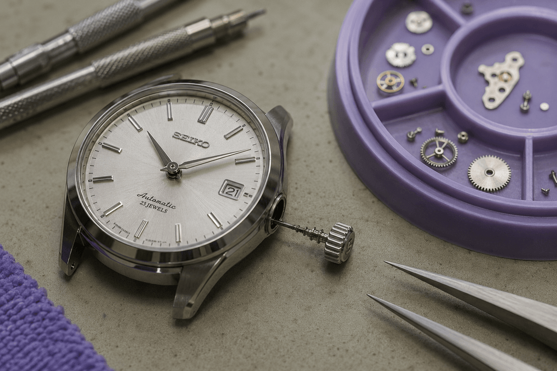 Luxury watch prepared for movement inspection with tools and components nearby.