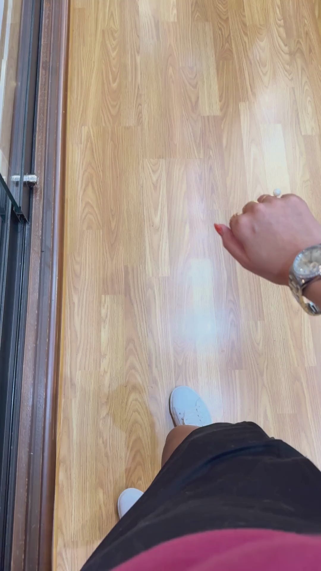 Rolex Datejust with diamond bezel worn on wrist, shown with gold jewelry over wood floor.
